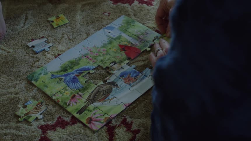 Mother and daughter assembling a puzzle over the rug in the living room