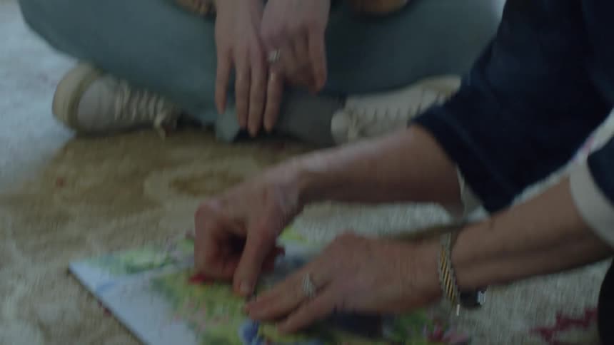 A man and woman high five after completing a puzzle