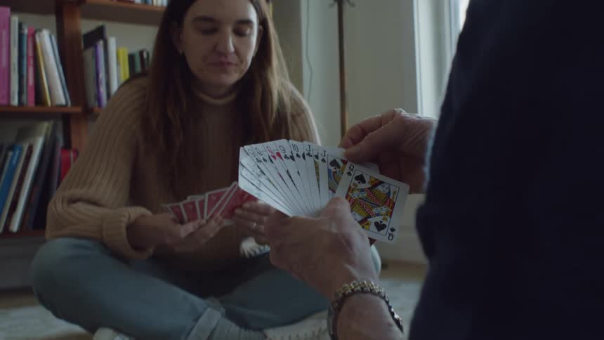 Two people are playing a card game together indoors