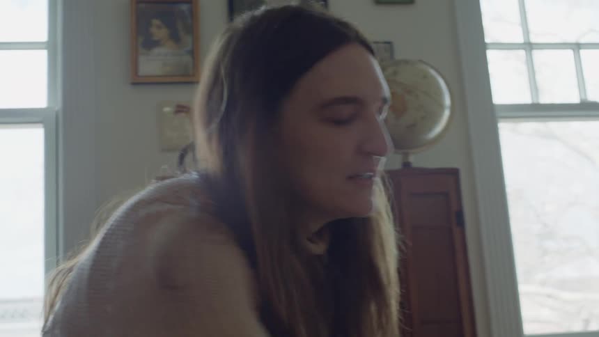 A woman is talking to someone and sitting in a room