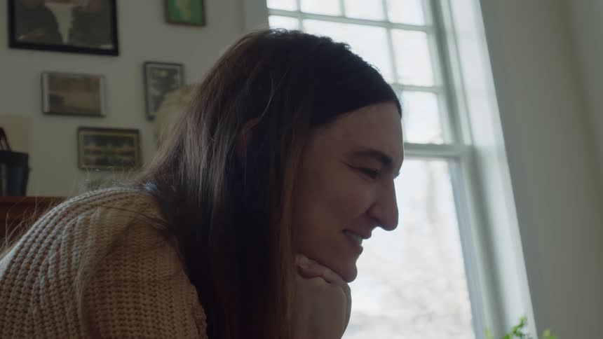 A closeup of a womans face as she is laughing smiling and talking