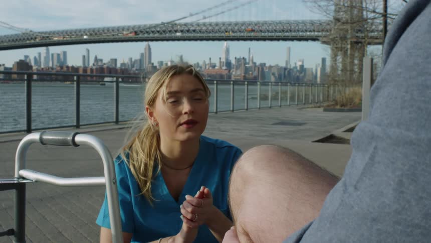 A nurse lectures her patient while outside next to the bay