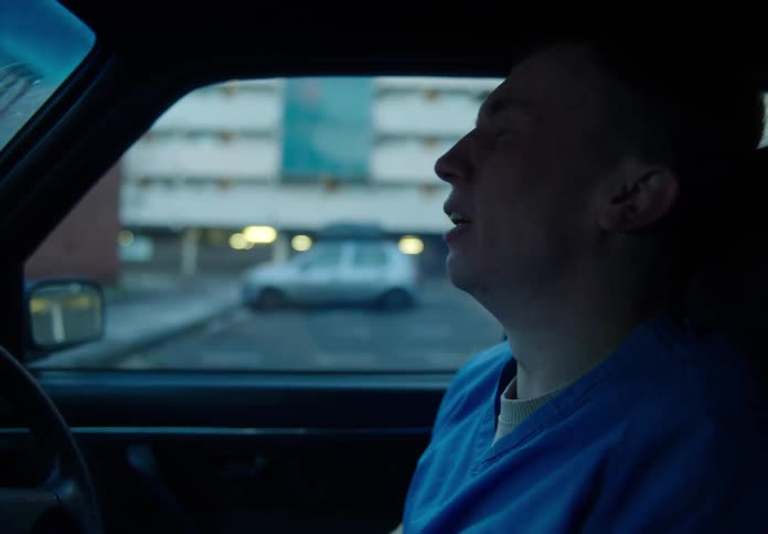 Medical person in scrubs gets into parked car and starts crying