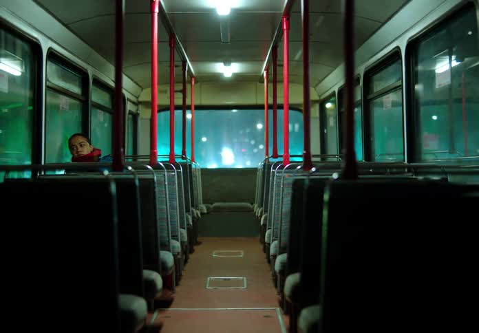 A person is riding public transportation during the night time