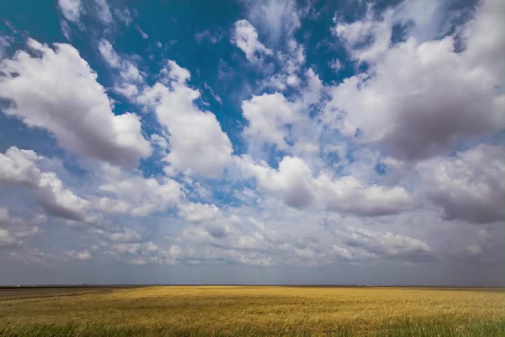 Time lapse of clouds floating over a field