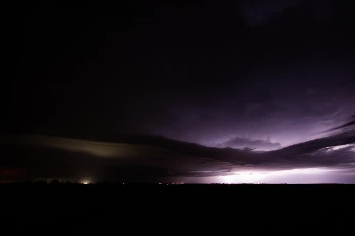 Lightning flashing in a dark cloudy night sky
