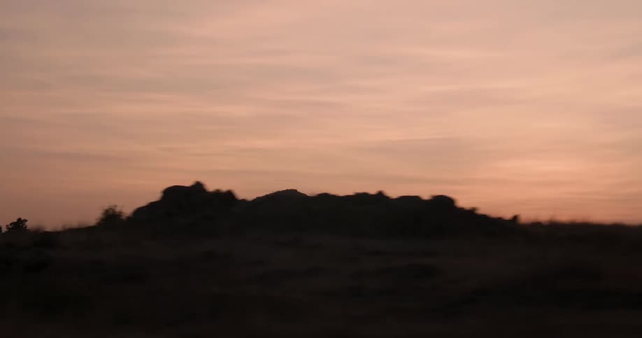 Sun sets over hills and plains