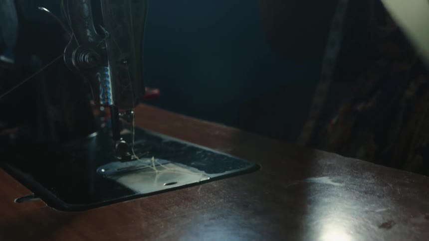 Woman with black shirt uses sewing machine
