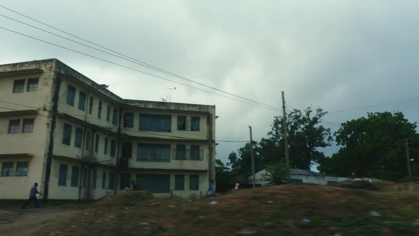 A city street is lined with run down homes and hotels
