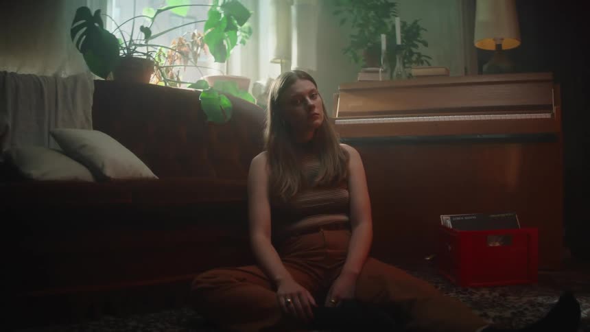A woman sits on the floor of her living room