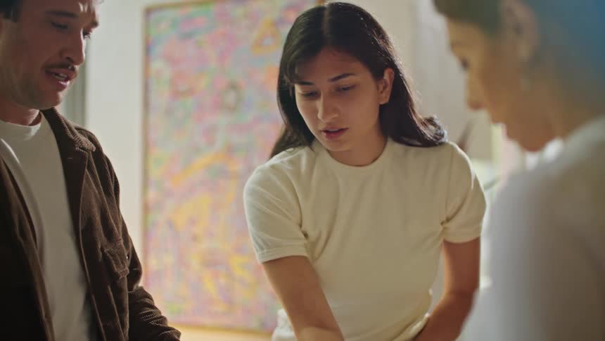 Coworkers stand around table discussing plans