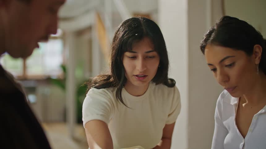 Colleagues discuss blueprints around a table