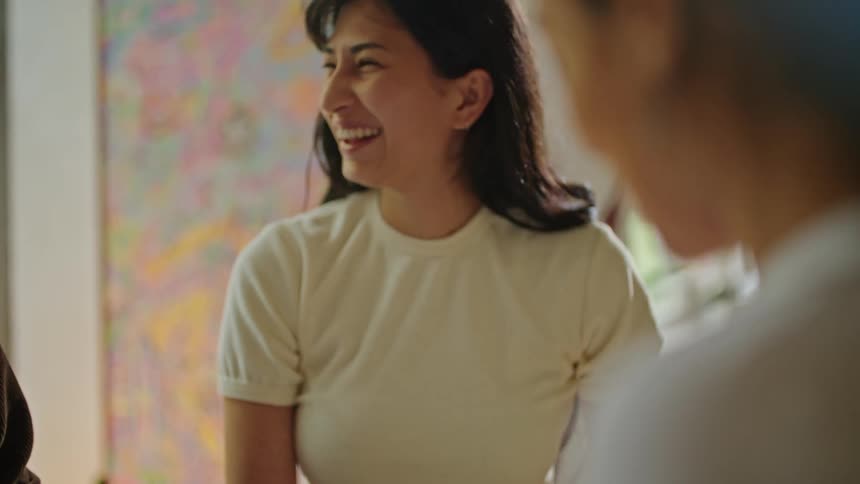 Man with brown jacket and women with white shirts work on plans smiling