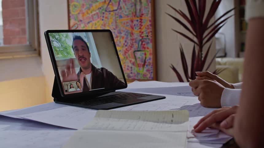 Coworkers meet via video on laptop