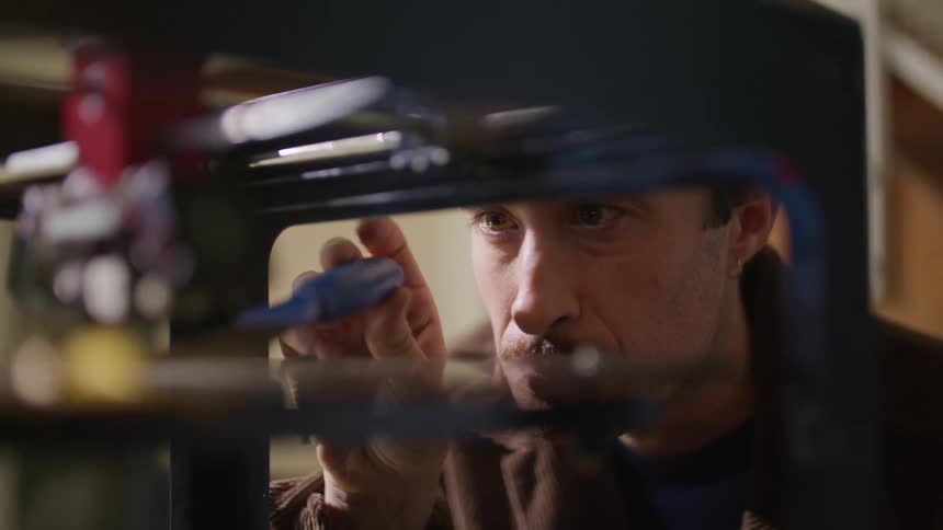 A young man is fixing something inside of his home