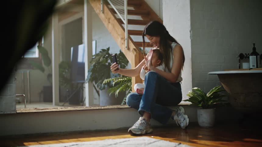 Mom at home with baby laughing and smiling taking a selfie