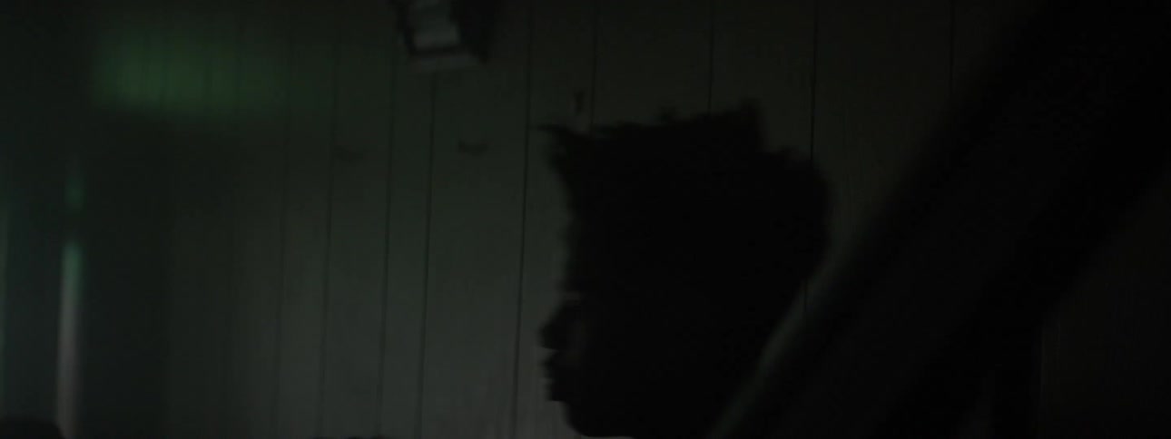 Two men fight in a dim room