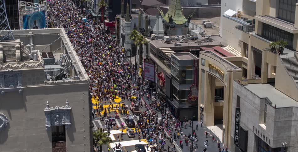 An aerial of a crowd of people on a city street gathered for an event