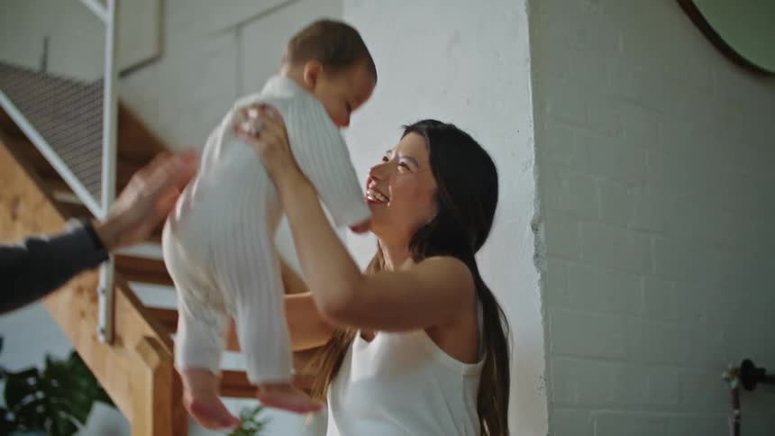 A young couple is playing with there baby inside of there home