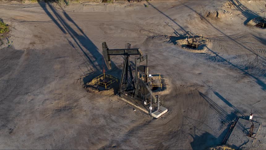A machine moves up and down at an oil well construction site