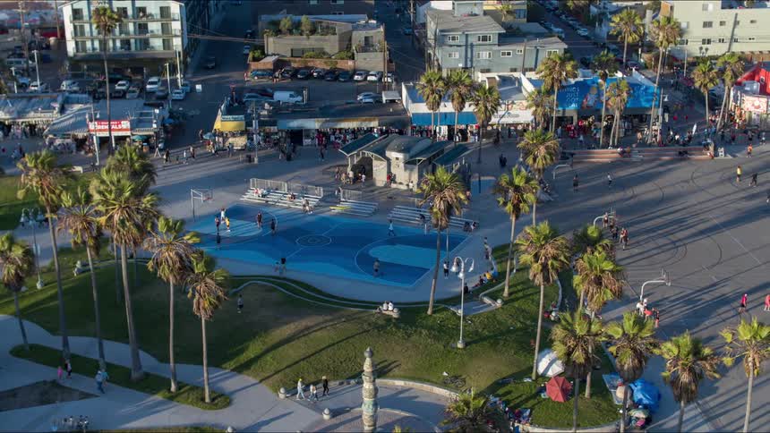 Aerial view of people playing basketball in courts and walking in the streets in downtown area in the city