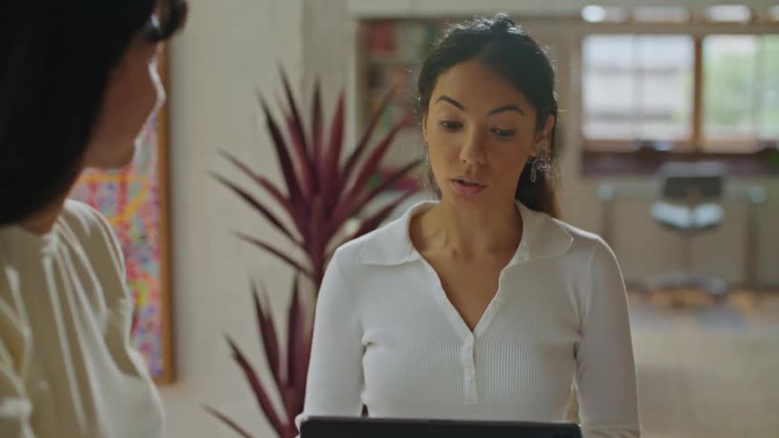 Two women are indoors and are working together