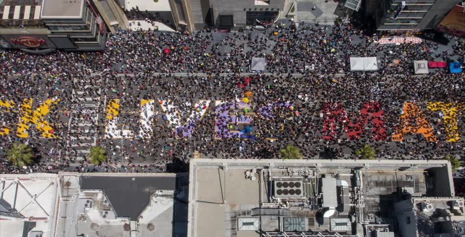 A huge crowd of people fill a downtown street during a black lives matter rally