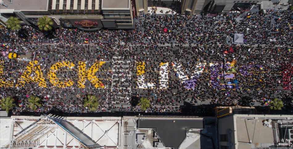 Aerial view of daytime march over all black lives matter mural on the street