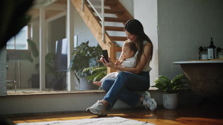 A woman uses her phone to take a selfie with her son