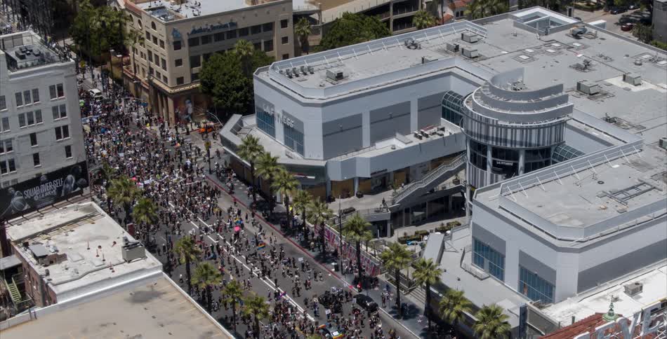 An aerial view of a crowd of people walking down a city street