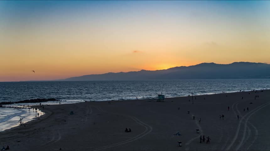 People are having fun at the beach during dusk
