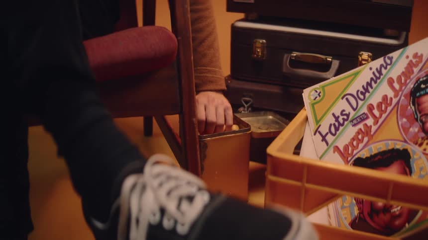 A person reaches their hand into a container full of snack foods