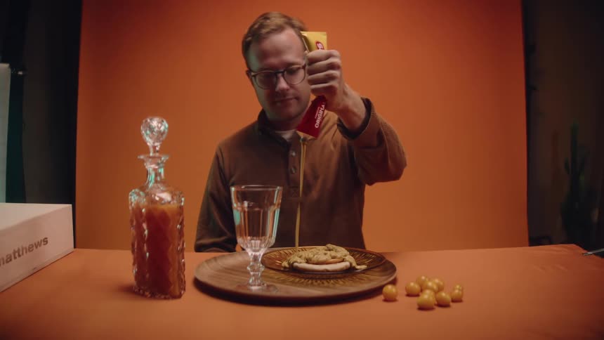 A man squeezes sauce onto a plate of food