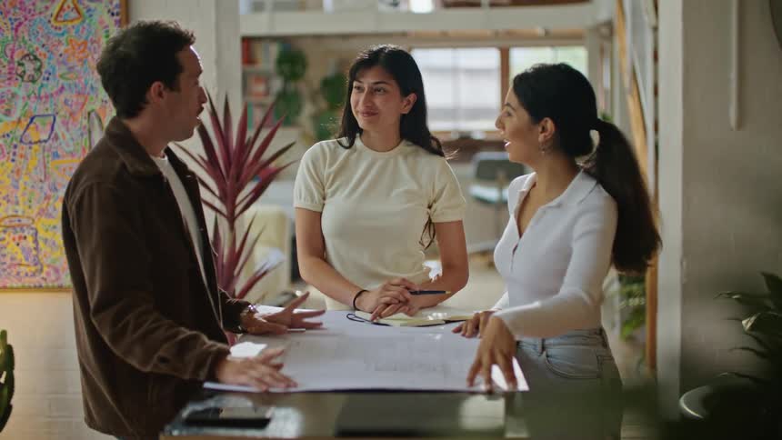 A man discussing plans with two woman