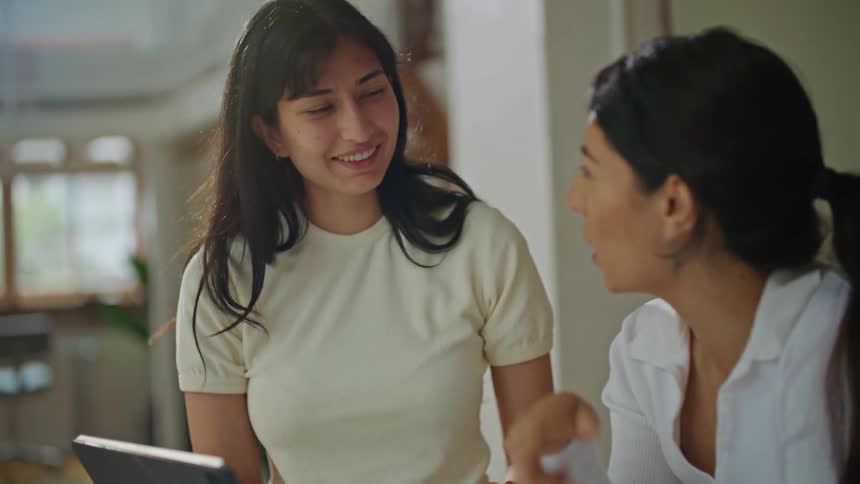 Two women are talking and looking at a template