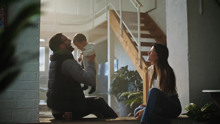 The view is of parents playing with their baby indoors