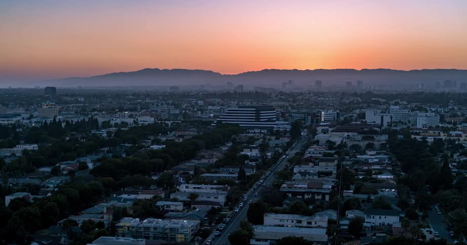 An aerial of a city at dusk with light fog settling over the city