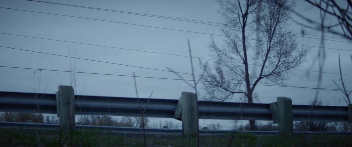 A guardrail protects passing vehicles from falling down a sloped ditch
