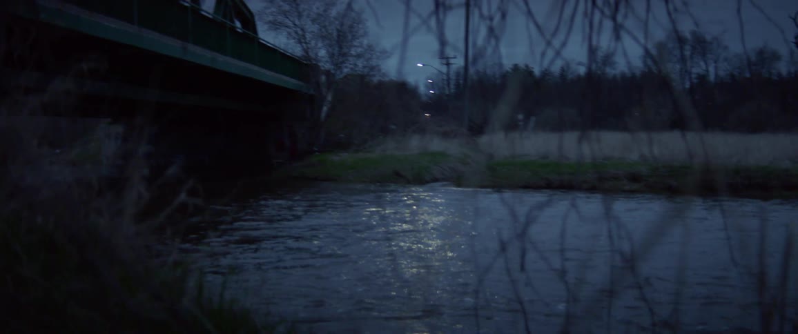 A river rushes under a metal bridge