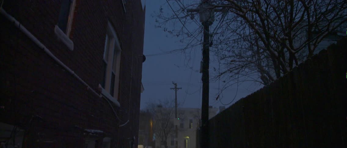 A snowy alleyway at night