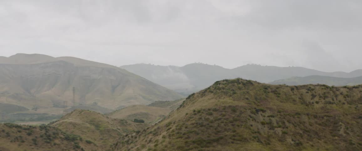 The camera looks out over rolling hills