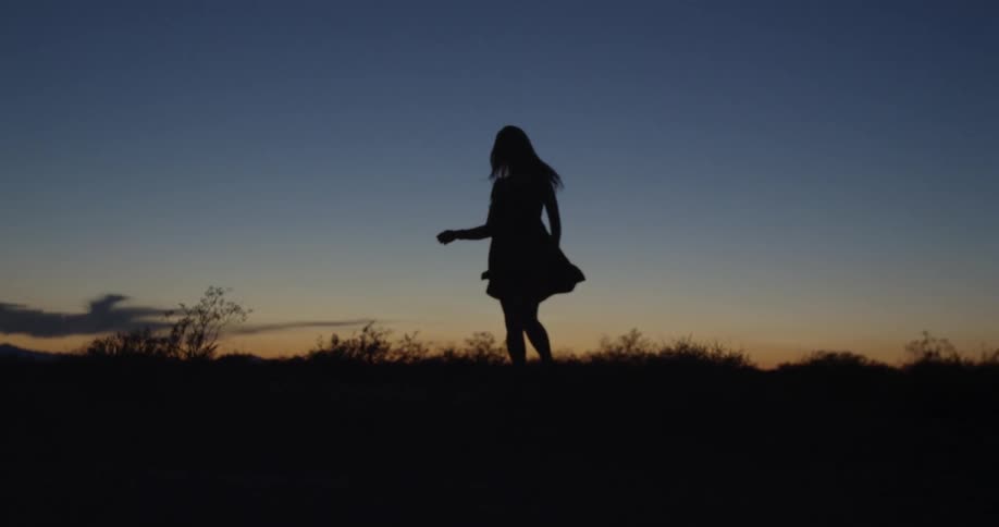 A woman spins around at dawn