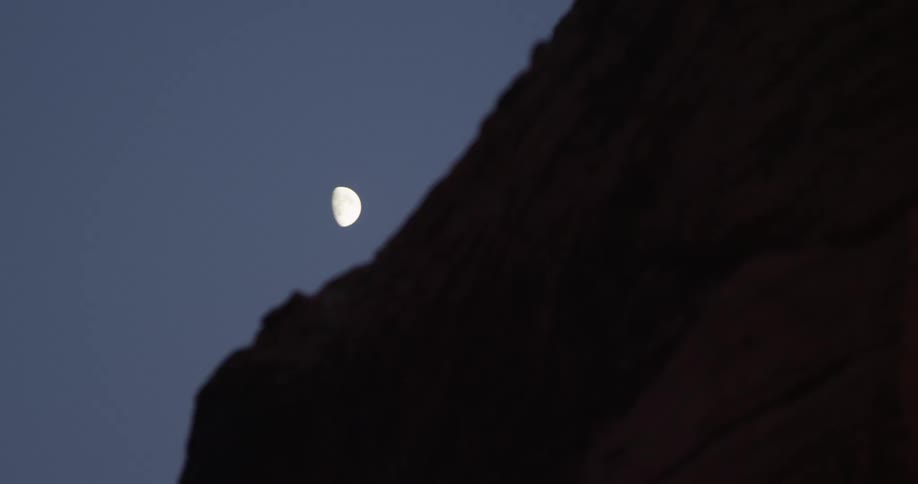 A half moon is in the clear sky