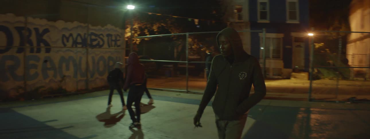 Kids are playing outside in a court at night
