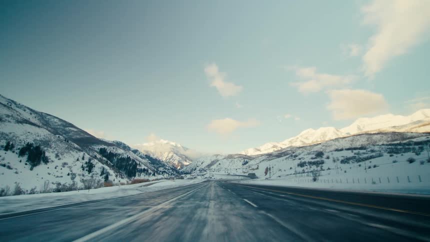 A view of a car going down a road in a mountain