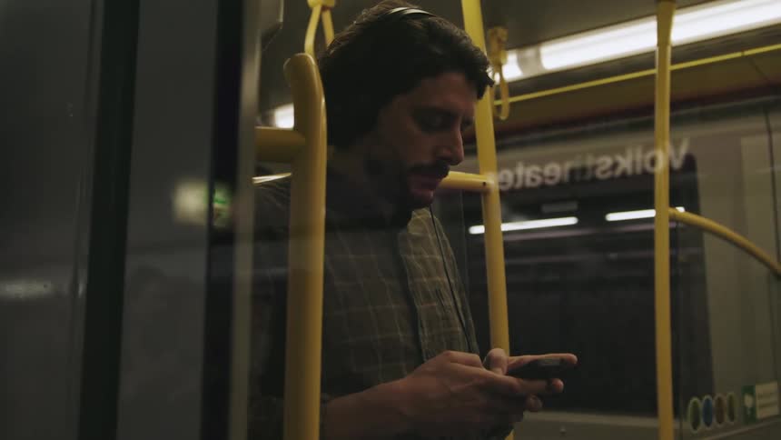 A man is texting while riding on public transportation
