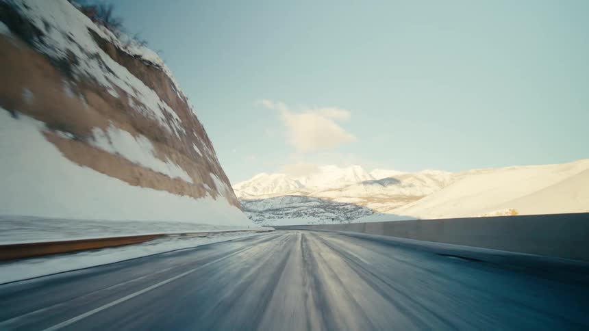 A widescale of a mountain range while moving on a road