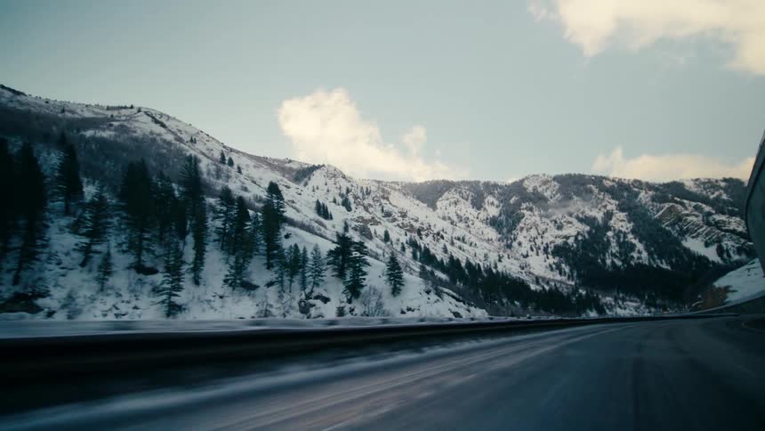 Highway passes through snow and conifer covered mountains