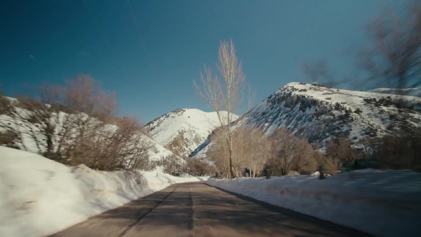 Vehicle drive on highway near the snowy mountains