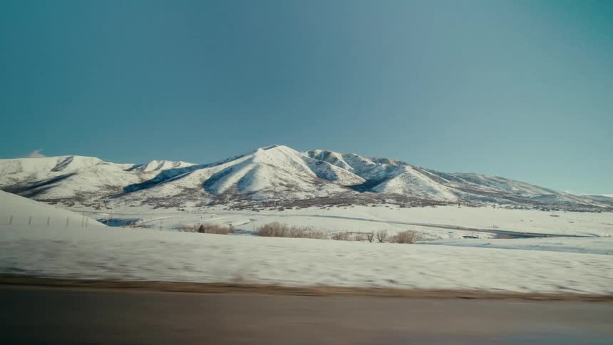 A distant mountain covered in snow in the countryside on a clear day
